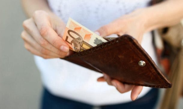 Foto von Frau, die einen Fünzig-Euro-Schein aus ihrem Portemonnaie holt