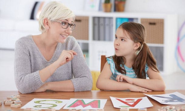 Lehrer bringt kleinem Mädchen das Alphabet bei