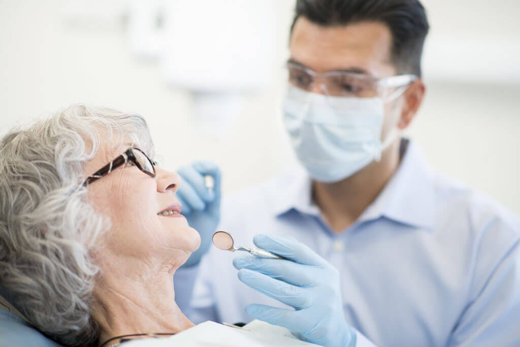 Zahnarzt behandelt ältere Frau